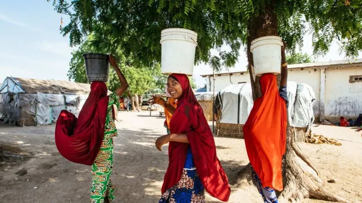 Des femmes portant des seaux  dans le camp de Fariya au Nigéria