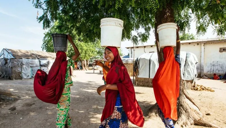 Des femmes portant des seaux  dans le camp de Fariya au Nigéria