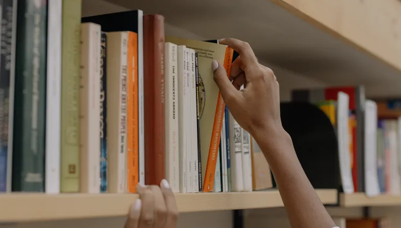 Main tirant un livre d'une étagère
