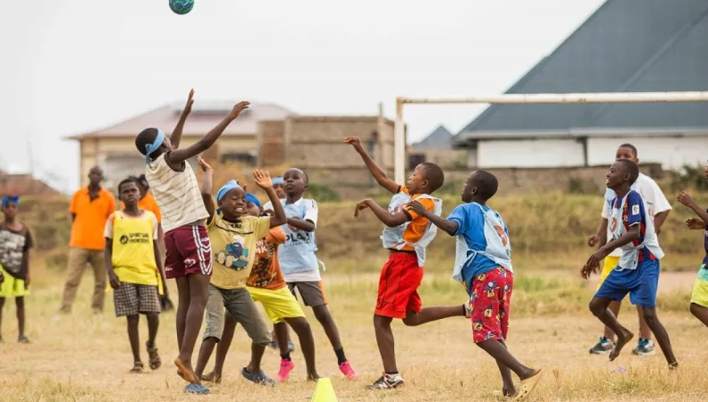 boys plaing football in a field 